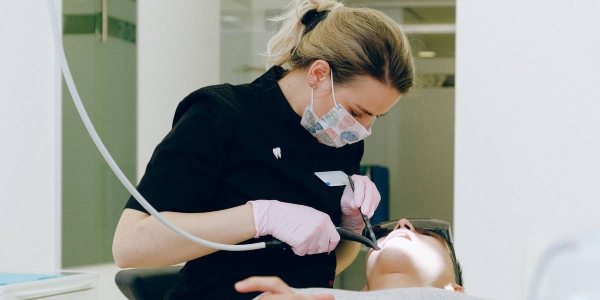 person getting teeth cleaned before being worked on with frenectomy procedure instruments